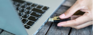 Hand inserting a USB stick into a laptop